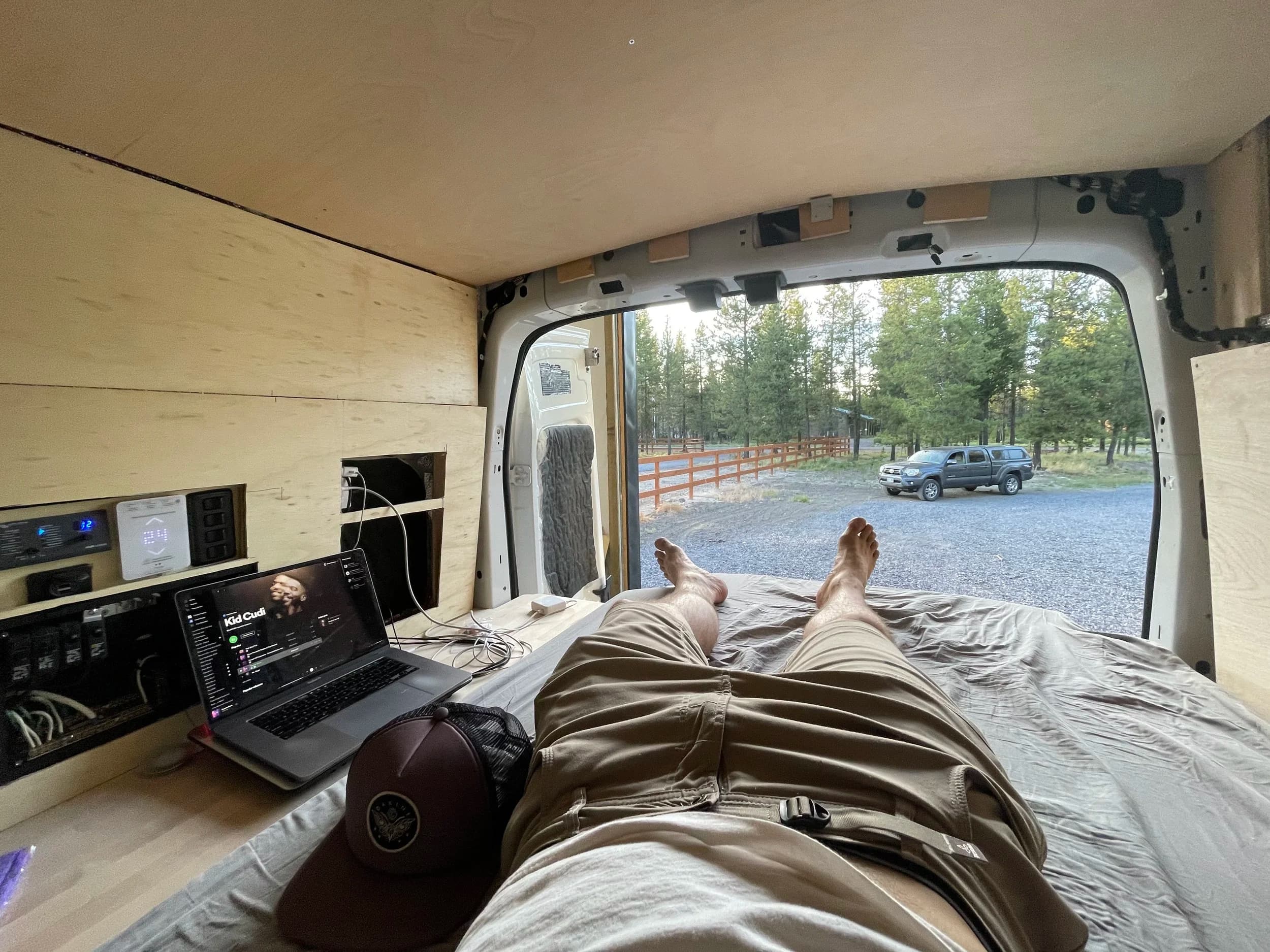 Relaxing on the bed with rear doors open to forest view